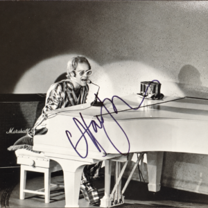 Elton John signed 8×10 black-and-white concert photo at a white piano, authenticated by Beckett BAS.